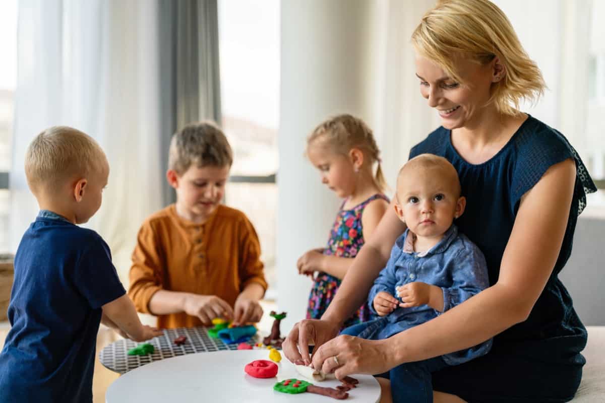 Woman and children playing together in a daycare center